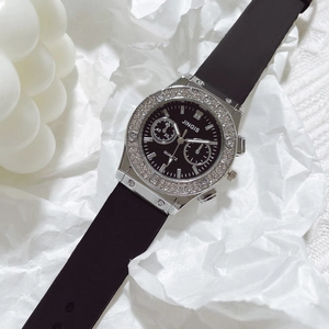 Macro shot of silver bezel with crystals and screw accents on a black silicone quartz watch