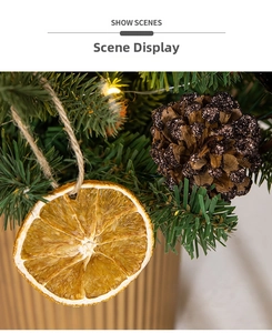 Macro di fette di arancia essiccata e pigne con luci su un albero di Natale