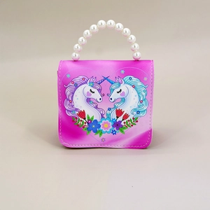 Detail of vibrant pink girls' mini bag with pearl handle and unicorn heart illustration