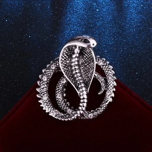 Detailed macro view of retro silver snake brooch with crystal scales on velvet