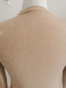 Detailaufnahme der feinen Stricktextur und Kragenverarbeitung am beigen V-Ausschnitt Pullover