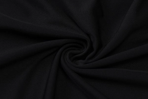 Close-up of black knitted fabric with fine ribbed texture on a summer sleeveless dress
