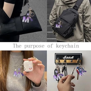 Detailed views of purple glitter letter M keychain on bags, earphone case and key holder