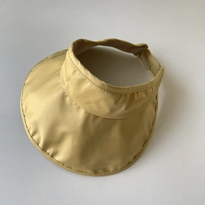 Close-up of the light yellow UPF50+ sun hat showing the fabric texture and wide brim