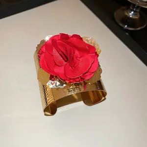 Metallic gold wide cuff bracelet with large red fabric rose flower and petal accents