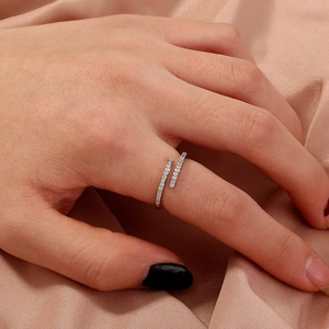 Adjustable silver ring with double-row white zircon stones worn on hand with silk background