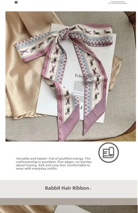 Detail of a pink and beige silk twilly scarf with horse patterns tied in a bow