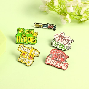 Detailed view of colorful enamel pins with motivational quotes and cat motifs