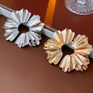 Elegant gold and silver leaf-shaped pleated metal earrings with textured floral design
