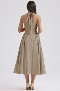 Detail of khaki halter neck backless dress featuring lace trim and pleated hemline