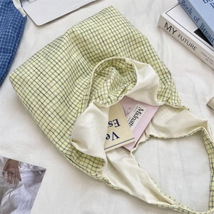 Macro detail of blue and yellow plaid tote bag with soft fabric texture and inner lining