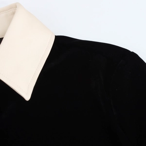 Détail du col contrasté crème sur ensemble en velours noir montrant la qualité des coutures