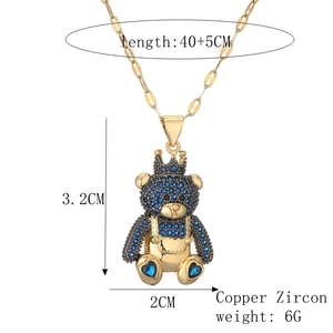 Macro shot of gold teddy bear pendant with blue zircon details and dimension labels
