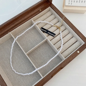 Detail of white pearl necklace with golden clasp in a wooden jewelry gift box