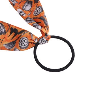 Halloween hair scrunchie with orange ribbon featuring pumpkin and skull patterns