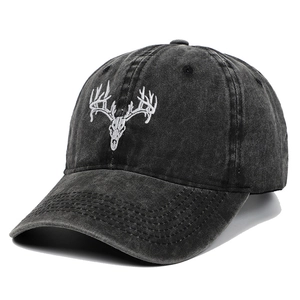 Detailed embroidery of a white deer skull on a vintage dark grey washed cotton baseball cap