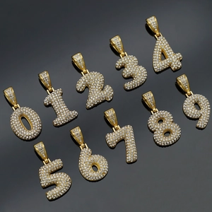 Macro view of gold-plated iced-out numbers 0-9 pendants with sparkling clear rhinestones