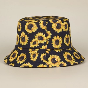 Vista detallada del vibrante estampado de girasoles en un sombrero de pescador negro de algodón.