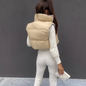 Rear view of women's quilted puffer vest in beige with stand collar and cropped fit