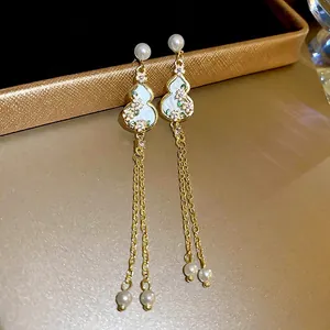 Elegant gold gourd earrings with pink floral patterns, long tassels, and white pearls