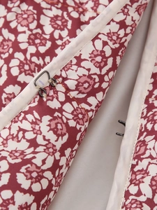 Close-up of metal hook-and-eye closure on floral print cotton jacket with red floral pattern