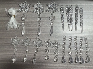 Detailed flat lay of transparent acrylic icicles and snowflakes with white ribbons
