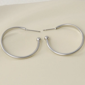 Detailed view of silver 304 stainless steel hoop earrings with bead ends on white background
