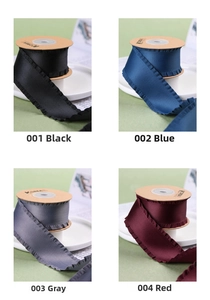 Détail de rubans en satin plissés en noir, bleu, gris et bordeaux sur bobines