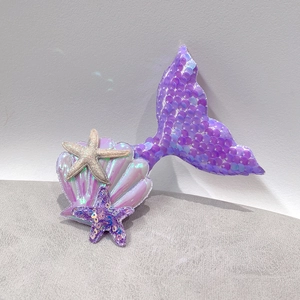 Detail of purple sequin mermaid tail and shell hair clips with glitter finish
