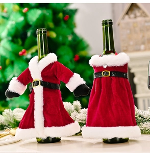 Close-up of red velvet Christmas wine bottle covers with white faux fur trim and gold buckle