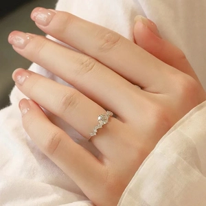 Elegant silver moissanite engagement ring with wave band shown on model's hand