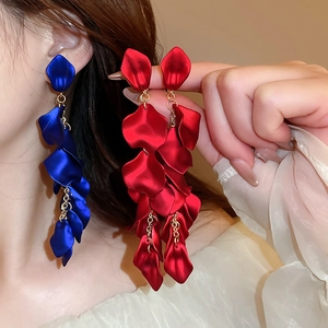 Detail of elegant floral petal tassel clip-on earrings in vibrant red and blue colors