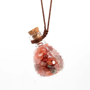 Glass perfume bottle pendant with red crystal stones and brown braided rope on white background