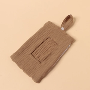 Detail of caramel cotton gauze diaper caddy showing soft texture and snap button strap