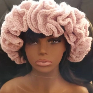 Detailed knit texture of a pink ruffled crochet beanie with wavy edge design