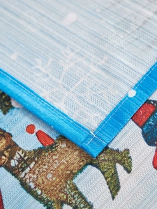 Close-up of precision stitching and woven texture on Christmas reindeer tablecloth