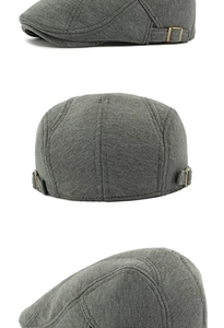 Detail of dark grey knit newsboy cap showing bronze metal buckle and fabric texture