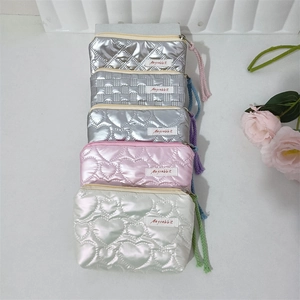 Close-up of assorted quilted heart and lattice patterns on PU leather cosmetic bags