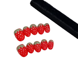 Handmade strawberry themed 3D press-on nails with red base and green leaf accents
