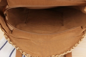 Detail view of the woven paper rope beach bag showing inner lining and small pocket