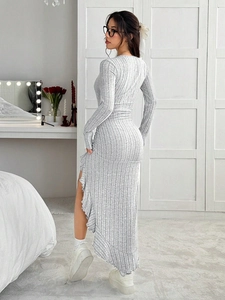 Detail view of the asymmetric ruffle hem and ruched side of the grey knit dress