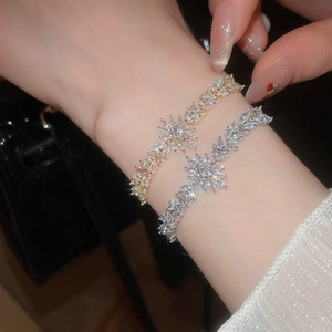 Détail macro de bracelets fleurs de blé or et argent avec zircons brillants