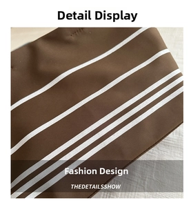 Detailed macro view of dark coffee canvas tote with stylish white stripes and neat stitching