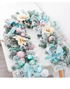 Détail de guirlande de Noël enneigée avec boules macarons et nœuds en soie