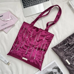 Detail of velvet tote bag with pearl embroidery and geometric patterns on plush fabric