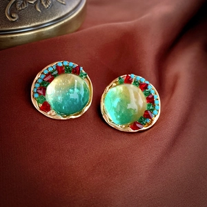 Boucles d'oreilles vintage avec verre vert et cristaux sur fond de soie rouge-brun