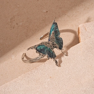 Detailed close-up of a vintage silver open cuff featuring a blue marbled resin butterfly
