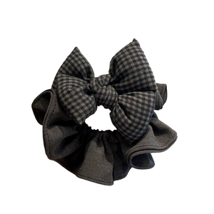 Chouchou en denim gris foncé avec nœud à carreaux noir et gris sur fond blanc