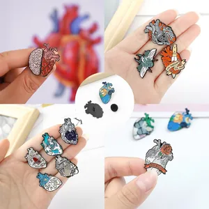 Artistic enamel pins set with anatomical heart, brain and Van Gogh inspired motifs