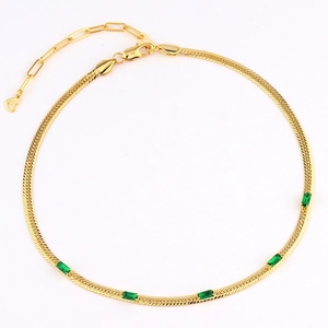 Detailed view of gold snake chain necklace with green rectangular crystals on white background